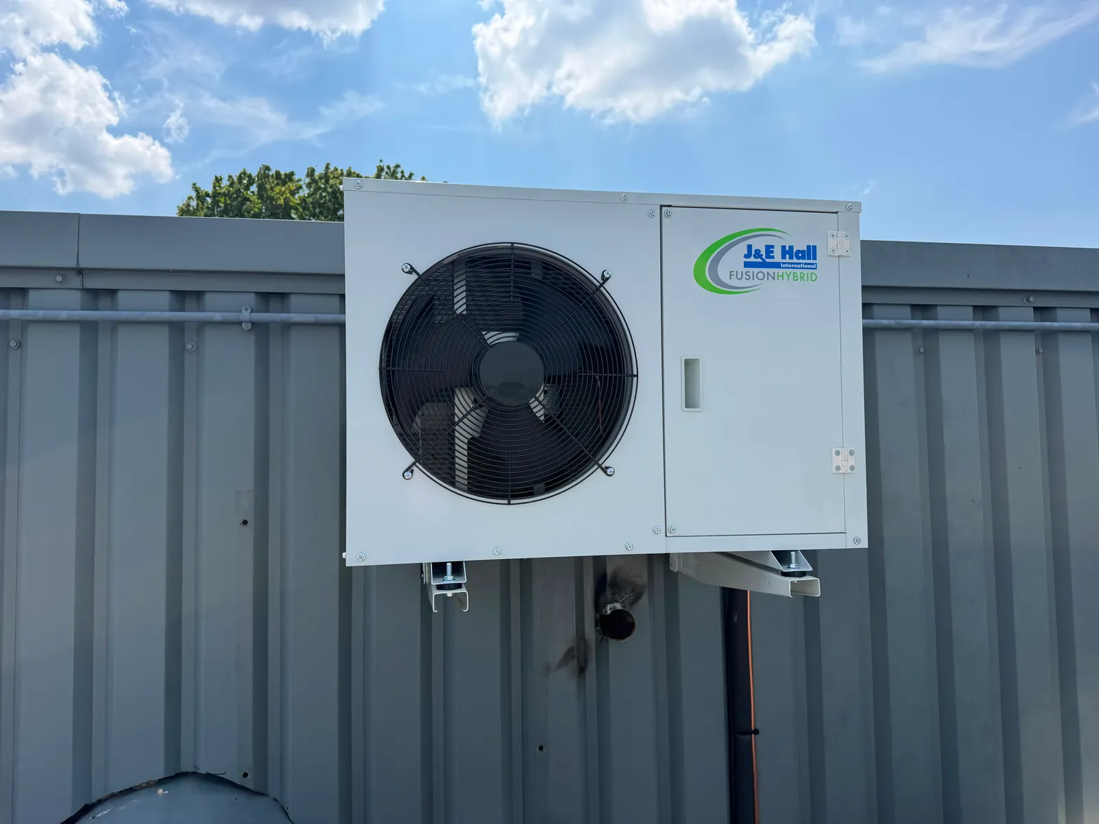 AC condenser unit mounted on a brick wall