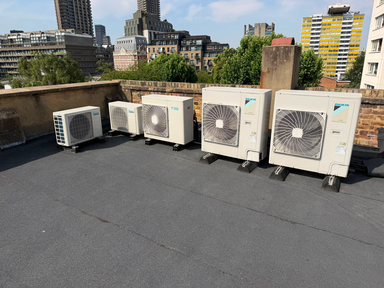 Bank of refrigeration condenser units installed on a flat commercial roof